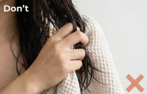 Hình ảnh cảnh báo sai lầm khi dùng khăn vò mạnh tóc ướt làm bong tróc lớp biểu bì và gây gãy rụng.